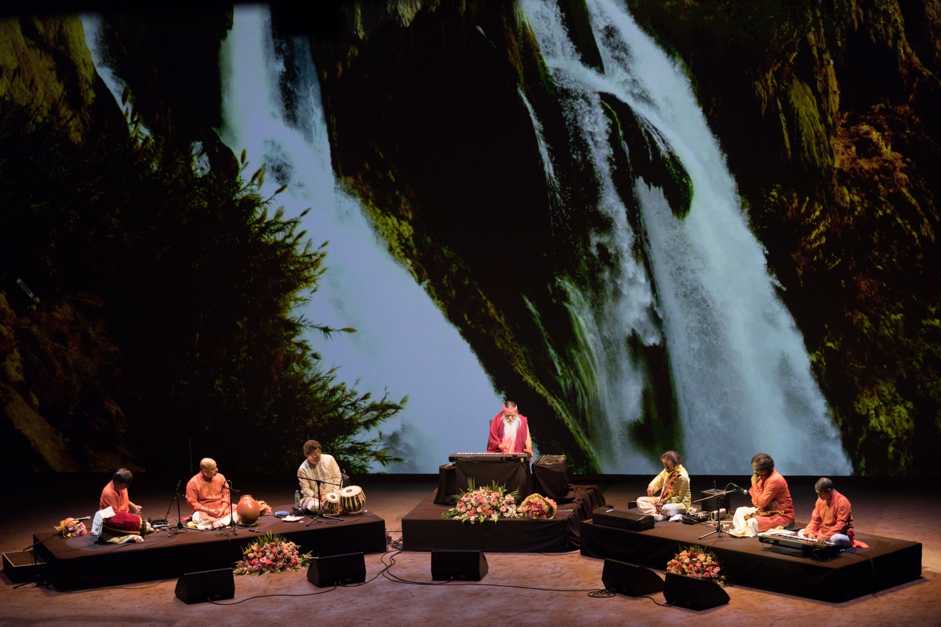 Healing Music Experience — Sri Swamiji with ensemble, waterfall backdrop