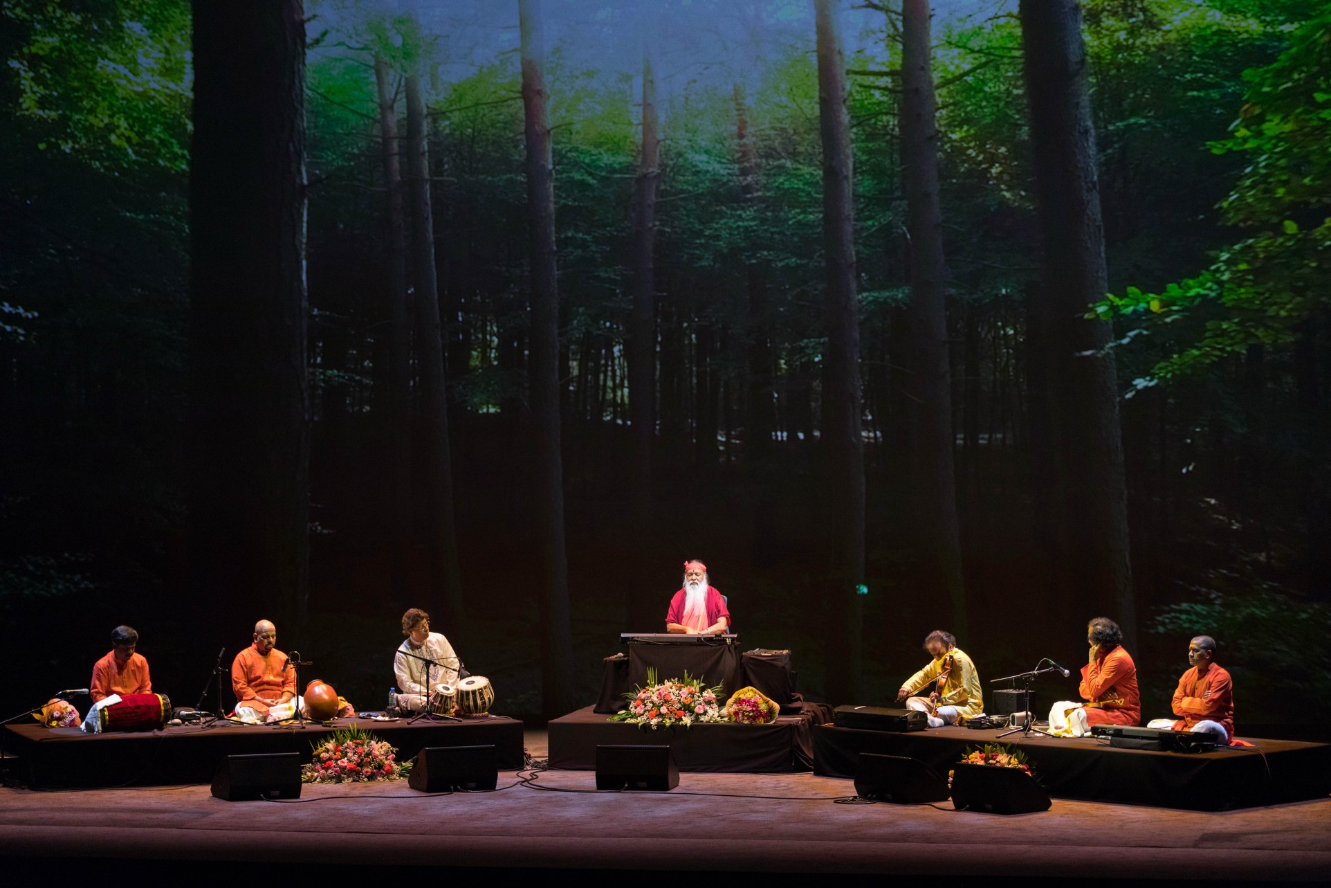 Healing Music Experience — Sri Swamiji with ensemble, tall forest backdrop