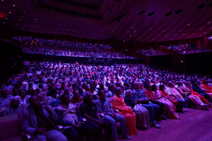 Healing Music Experience audience — packed hall, purple light